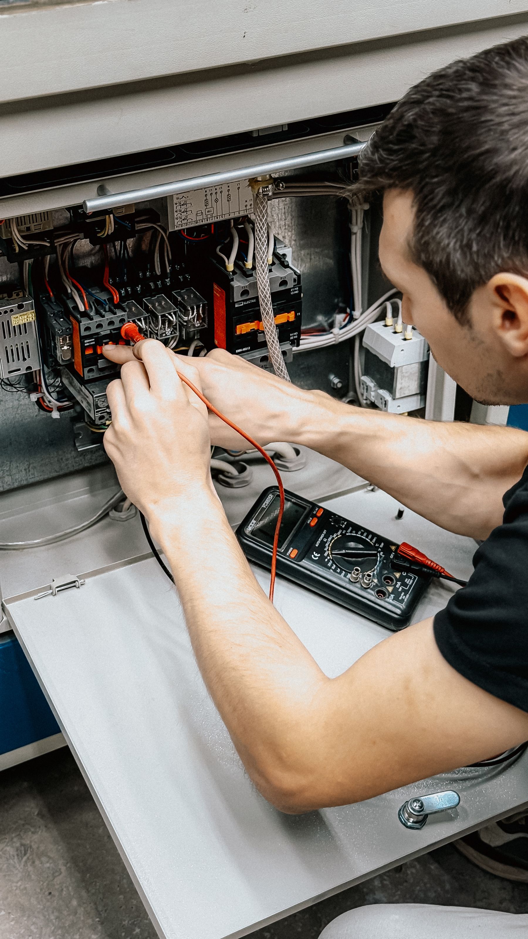 Electrician explaining an electrical panel to a property owner during a consultation
